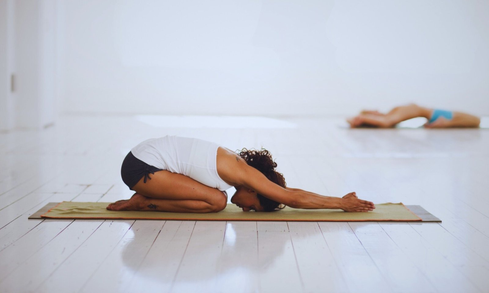 Mujer practicando Ashtanga Yoga en postura de Balasana durante clase individualizada en estilo Mysore