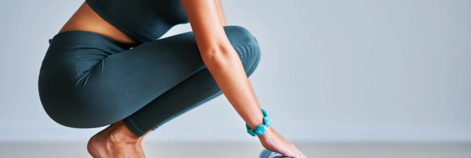 Mujer desenrollando una esterilla de yoga en un ambiente tranquilo.